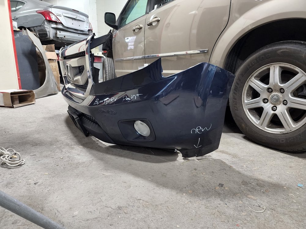 Damaged navy bumper cover removed for repair and paint