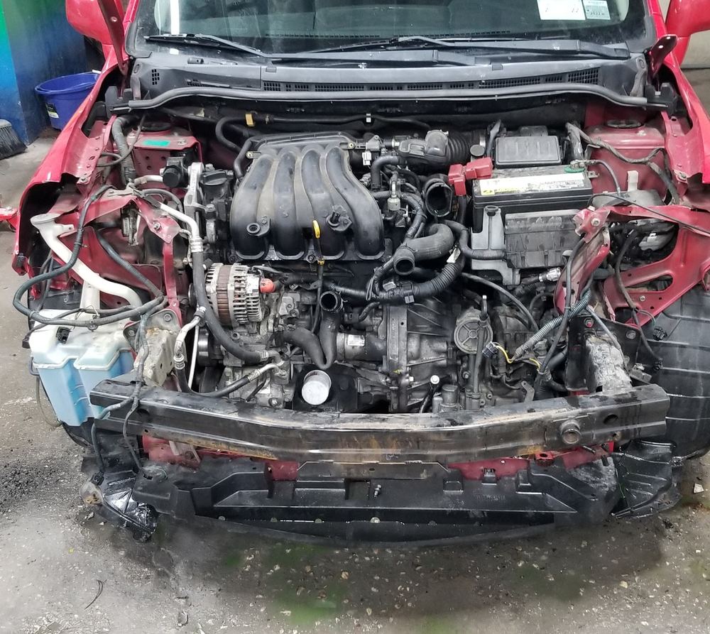 Red car with front-end collision damage, bumper removed